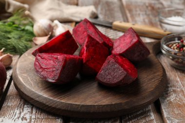 Pancar kökü, baharat ve bıçağı ahşap masaya yakın plan.