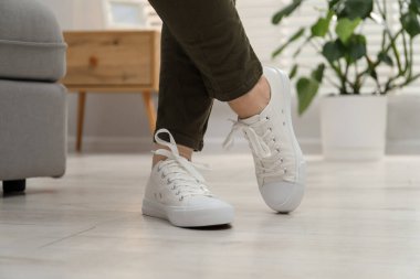 Evde şık ayakkabılar giyen bir kadın, yakın plan.