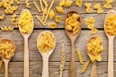 Farklı türde hamur makarnalar, kaşık ve çiviler, tahta masa, düz yatış.