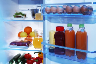 Farklı taze gıda ürünleri olan modern buzdolabı, yakın plan.