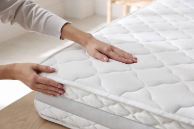 Yatakta yumuşak yatağa dokunan kadın, yakın plan.