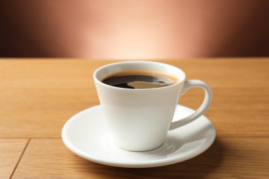 Ahşap masada, fincanda Aromatik kahve, yakın plan.