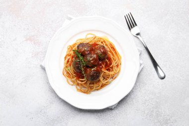 Açık gri masada servis edilen köfteli leziz makarna.