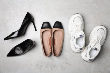 Gri desenli zeminde, düz yerde farklı güzel ayakkabılar.