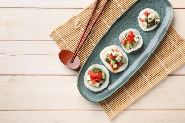 Sebzeli lezzetli pirinç kağıdı cipsi, beyaz peynir ve siyah susam tohumları açık ahşap masa, üst manzara. Metin için boşluk