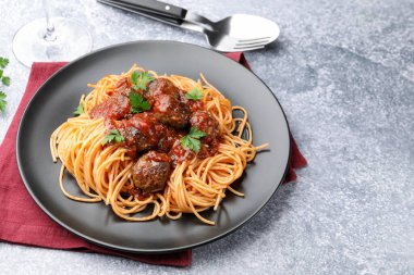 Gri masada servis edilen köfteli lezzetli makarna, yakın plan. Metin için boşluk