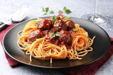 Gri masada servis edilen köfteli lezzetli makarna, yakın plan.