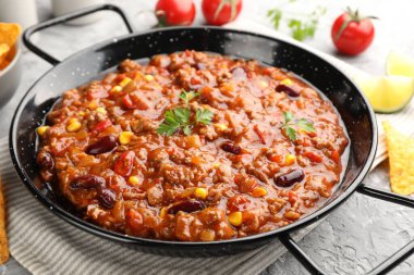 Lezzetli chili con carne servis edilmiş gri masa, yakın plan.