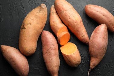 Siyah desenli masada çiğ patates, düz uzanmış.