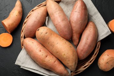 Siyah desenli masada çiğ patates, düz uzanmış.