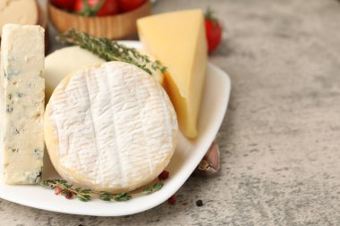 Gri masada servis edilen farklı taze süt ürünleri, yakın plan. Metin için boşluk