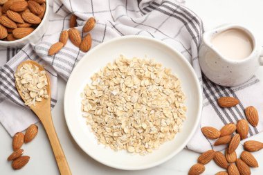 Yulaf gevreği, badem sütü ve fındıklar beyaz mermer masada, düz yatıyordu.