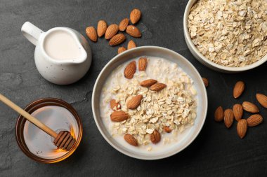 Badem sütlü lezzetli yulaf ezmesi, fındık ve bal siyah masada, düz yatıyordu.