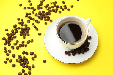 Kahve fincanda tazeleniyor ve fasulye sarıda.