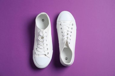 Mor arka planda bir çift şık spor ayakkabı, üst görünüm.