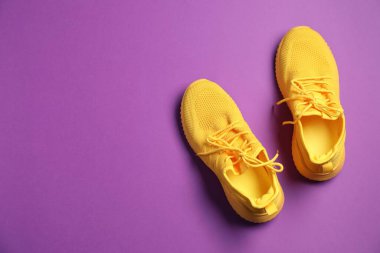 Mor arka planda bir çift şık spor ayakkabı, üst manzara. Metin için boşluk