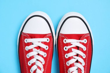 Pair of stylish sneakers on light blue background, top view