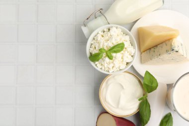 Farklı süt ürünleri ve fesleğen beyaz fayanslı masa, düz yatak. Metin için boşluk