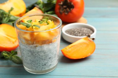 Hurmalı lezzetli chia pudingi ve açık mavi ahşap masada nane şekeri. Yakın plan.