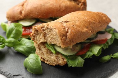 Jambonlu, sebzeli ve fesleğenli baget sandviçler.