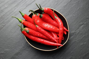 Koyu gri masada kasede olgun kırmızı biber, üst manzara.