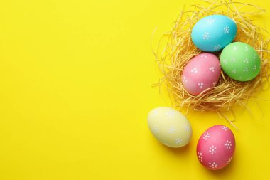 Birçok kişi sarı arka planda Paskalya yumurtası ve saman boyadı. Metin için boşluk