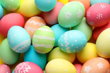 Many painted Easter eggs on yellow background, flat lay