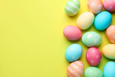 Sarı arka planda güzel dekore edilmiş Paskalya yumurtaları. Metin için boşluk