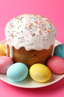 Enfes Paskalya pastası ve pembe arka planda süslü yumurtalar, yakın plan.