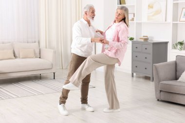 Güzel yaşlı çift evde dans ediyor.