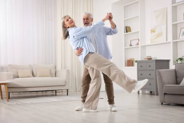 Güzel yaşlı çift evde dans ediyor.