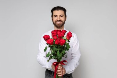 Sevgililer Günü. Hafif arka planda gül buketi olan yakışıklı bir adam.