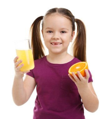 Bardakta portakal suyu ve beyaz arka planda meyvelerin yarısı olan küçük bir kız.
