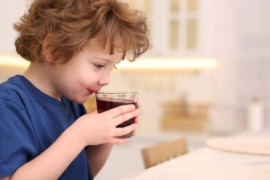 Küçük çocuk evde taze nar suyu içiyor. Metin için boşluk