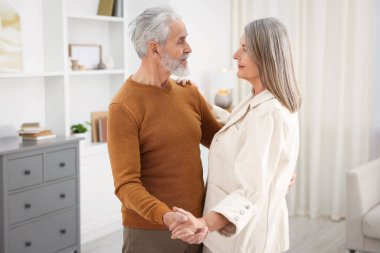 Güzel yaşlı çift evde dans ediyor.