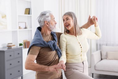 Güzel yaşlı çift evde dans ediyor.