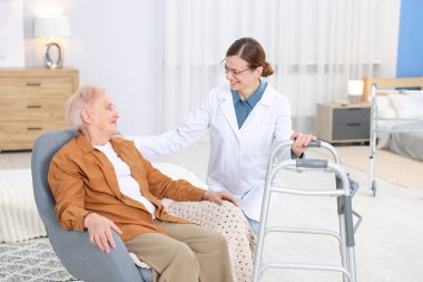 Huzurevinde Walker 'a yardım eden bakım işçisi.