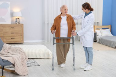 Huzurevinde Walker 'a yardım eden bakım işçisi.