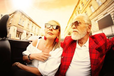 Üstü açılır arabada gezmekten hoşlanan şık yaşlı çift, geniş açılı mercek.