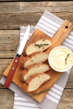 Tahta masada tereyağlı baget, kekik ve bıçak dilimleri.