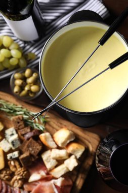 Erimiş peynir, şarap ve abur cuburla fondü tenceresi (caquelon).
