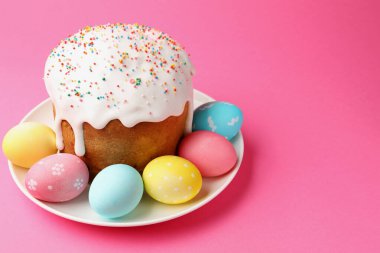 Enfes Paskalya pastası ve pembe arka planda süslü yumurtalar, yakın plan. Metin için boşluk