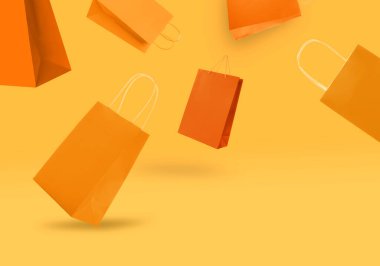 Turuncu arka planda alışveriş torbaları. Satış, sıcak teklif, indirim.