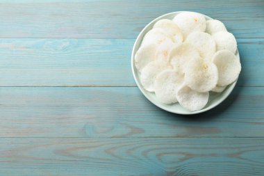 Açık mavi ahşap masa üzerinde leziz pirinç kağıdı parçaları, üst manzara. Metin için boşluk