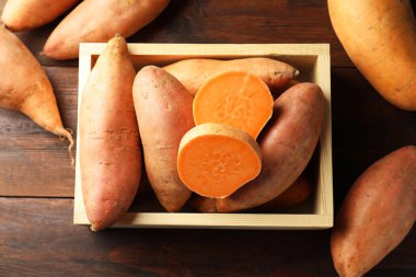 Tahta masadaki sandıkta çiğ patates.