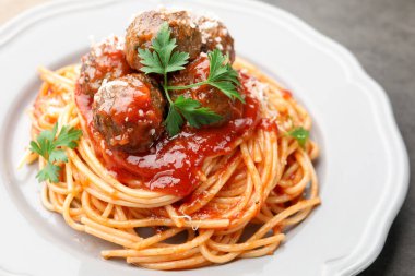 Köfteli ve peynirli lezzetli makarna. Gri masada, yakın plan.