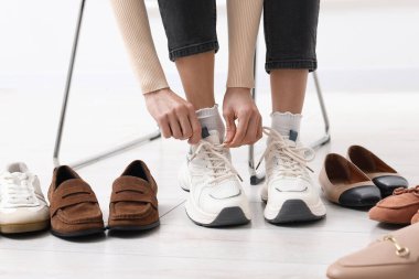 Kapalı mekanlarda farklı ayakkabılar deneyen kadın, yakın çekim