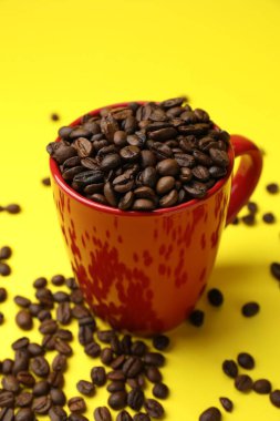 Sarı arka planda aromalı kahve çekirdekleri, yakın plan.