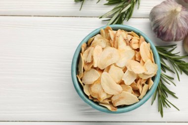 Kasede kurutulmuş sarımsak taneleri, taze sebzeler ve beyaz ahşap masa üzerinde biberiye, düz yatak. Metin için boşluk