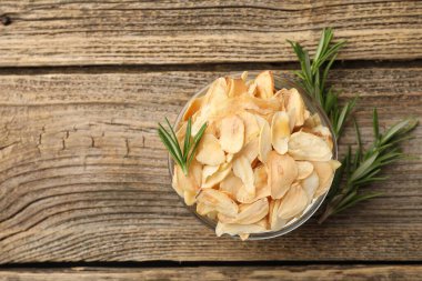 Kasede kurutulmuş sarımsak gevreği ve ahşap masada biberiye. Metin için boşluk